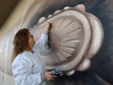 Local artist Jennifer Butts places a few finishing touches on the Lemoore Odd Fellows mural. It is located on the downtown business Ramblin' Rose.